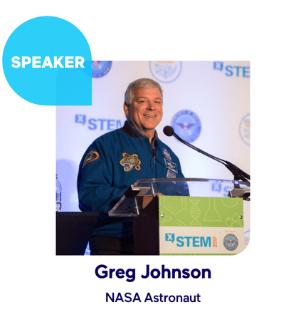 NASA astronaut speaking at X-STEM event with microphone on stage.
