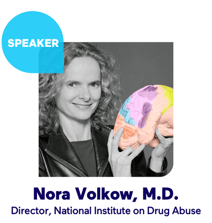 Black-and-white portrait of a speaker smiling and holding a colorful brain model with a 'SPEAKER' badge