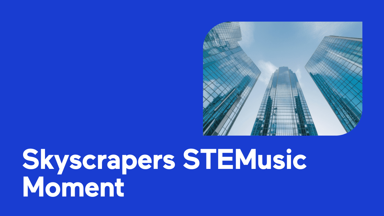 Looking up at modern glass skyscrapers against a blue sky.