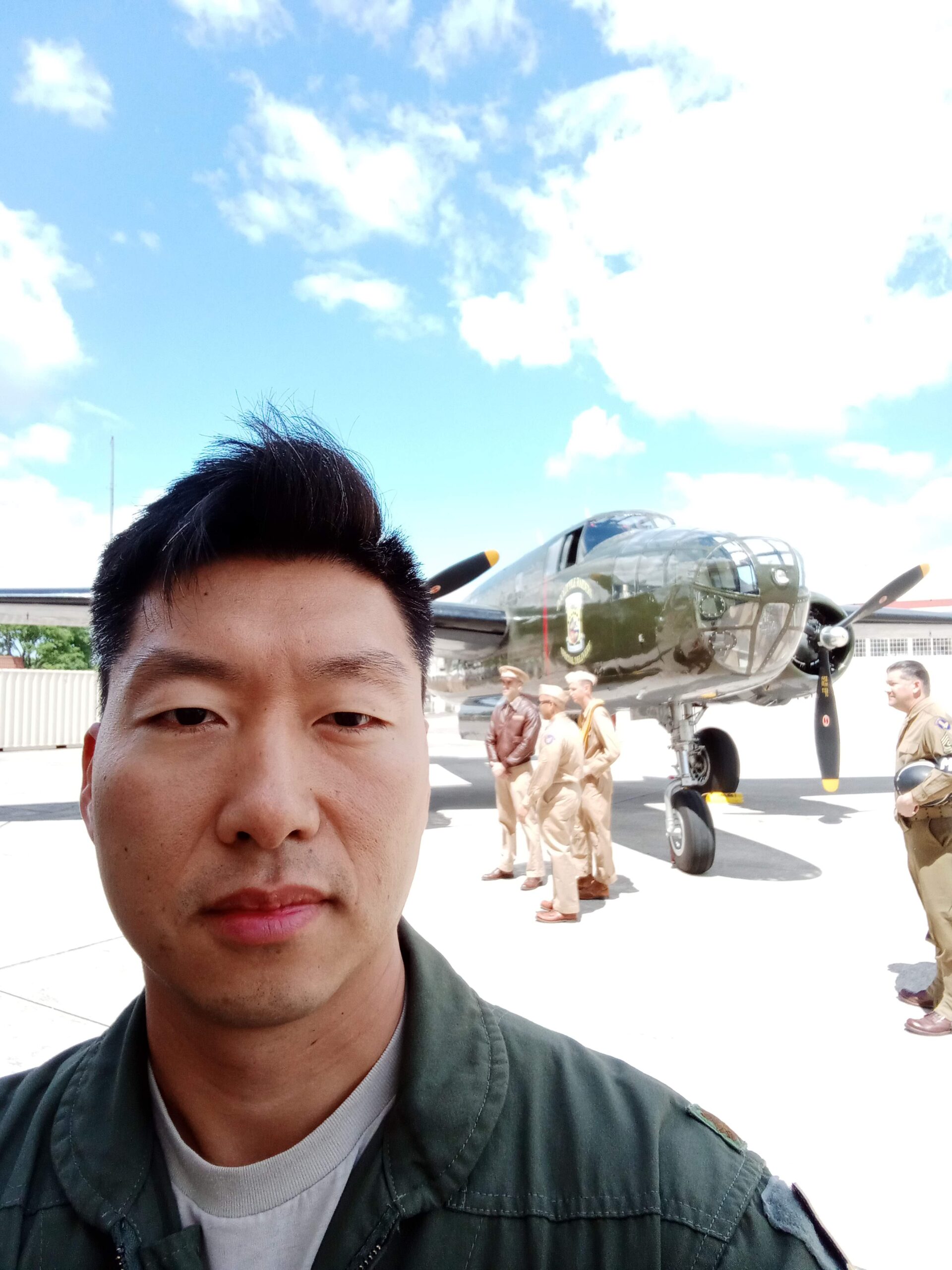 Man in uniform with vintage military plane in the background