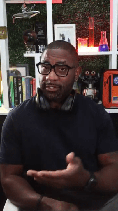Person speaking with laboratory equipment and books in the background