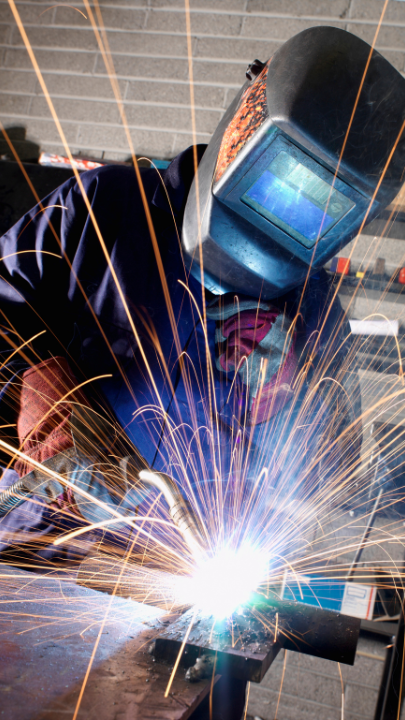 Welder working with bright sparks and protective gear