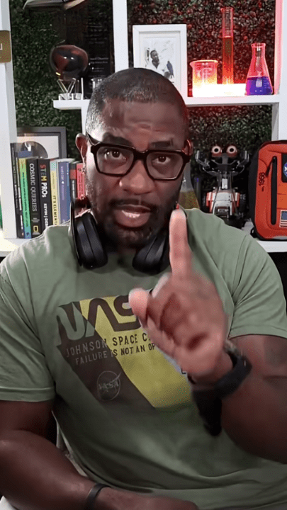 Man discussing software engineering in a tech-themed room with books and gadgets.