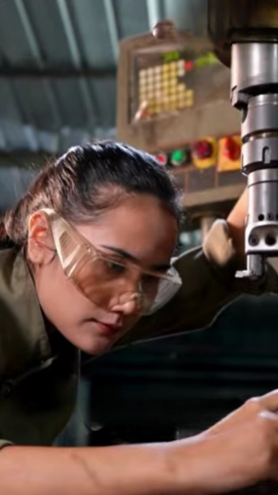 Person wearing safety goggles operating industrial machinery