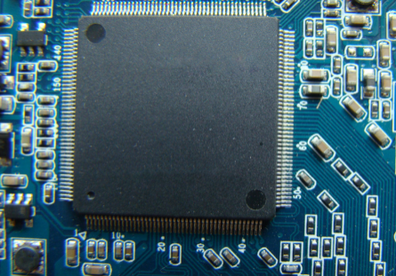 Close-up of a microchip on a blue circuit board.