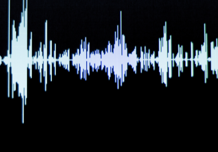 Close-up of digital sound waves on a dark screen