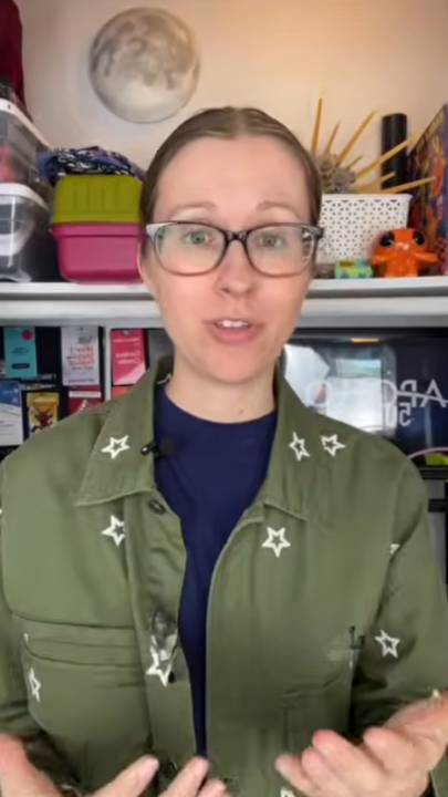 Person speaking in front of a shelf with storage boxes and craft items.