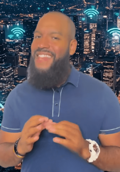 Man in blue shirt talking with city night skyline and wireless symbols