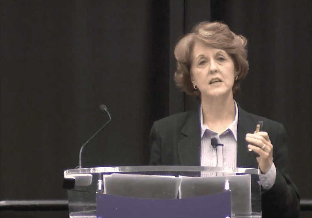 Woman speaking at a podium during a conference