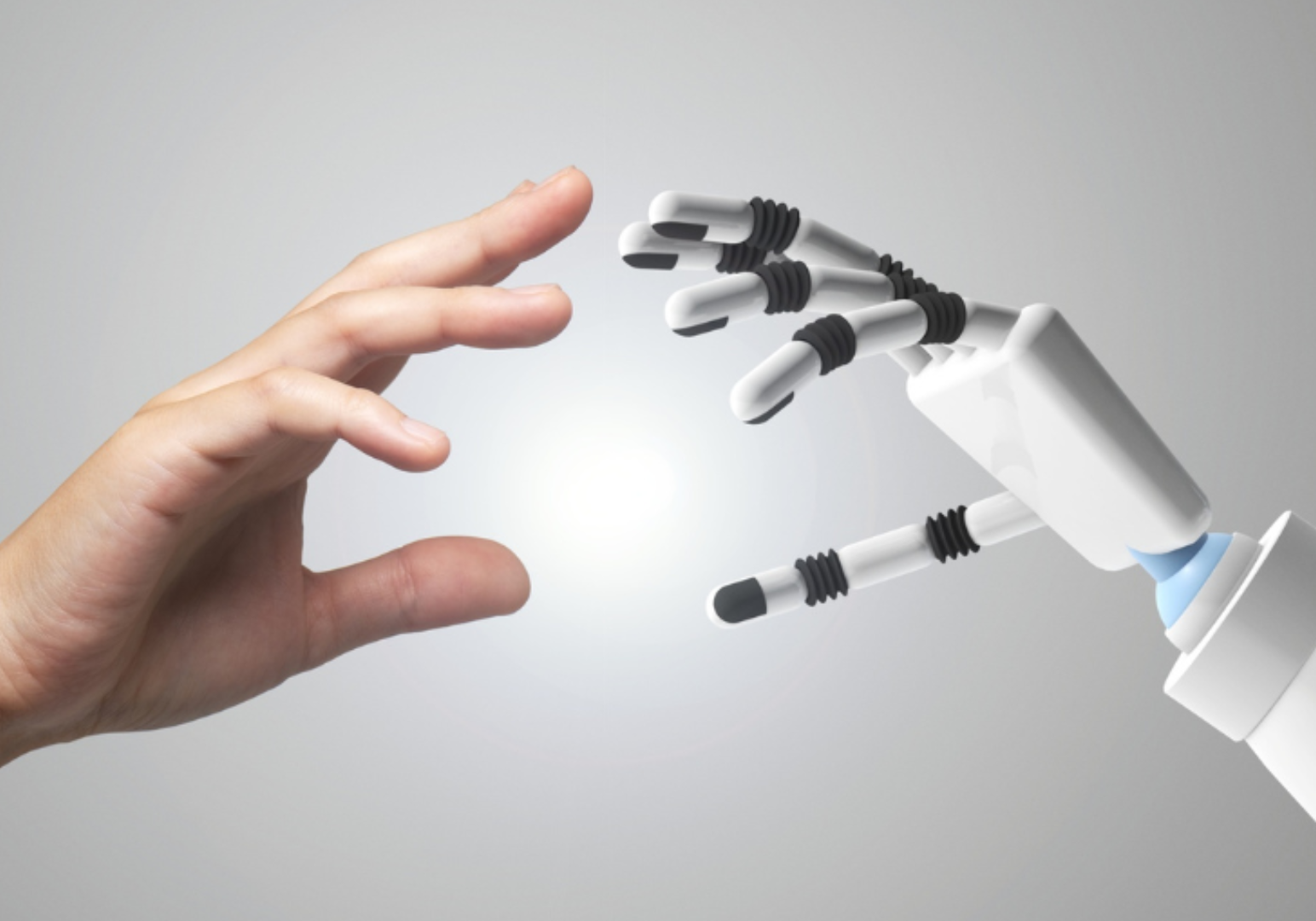 A human hand reaching towards a robotic hand in a symbolic gesture.