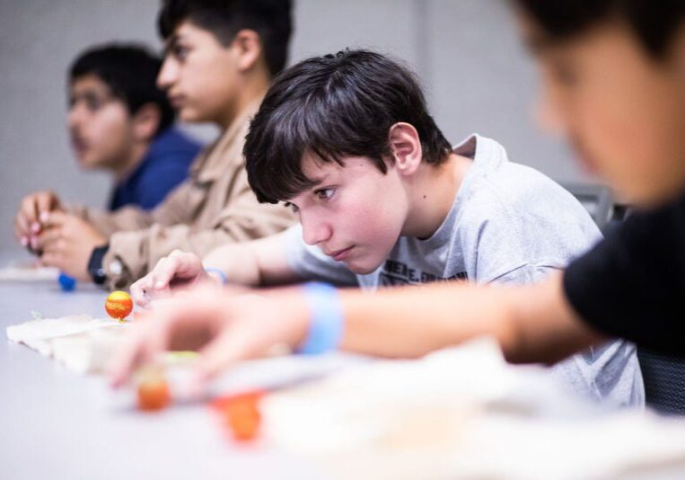 Students intently focused on building miniature models.