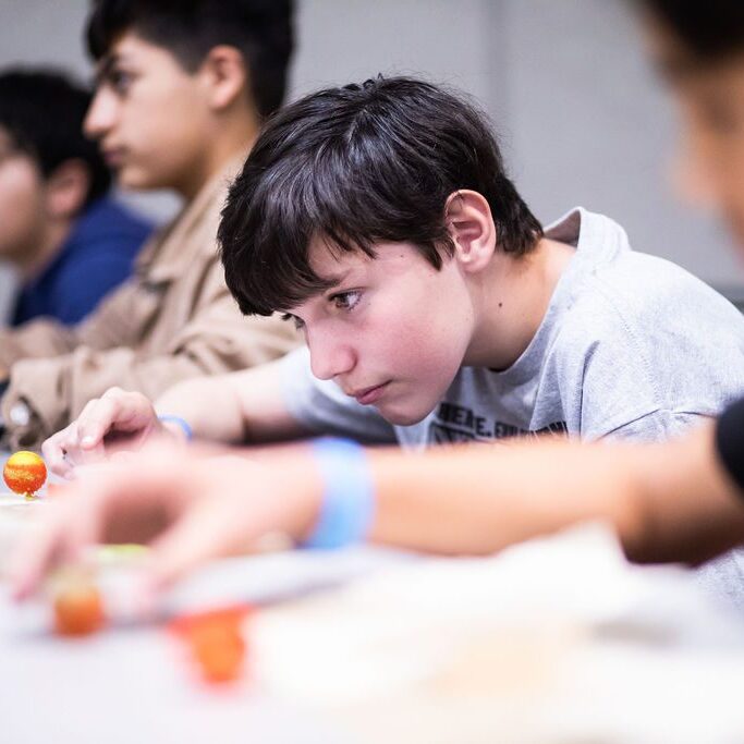Students intently focused on building miniature models.