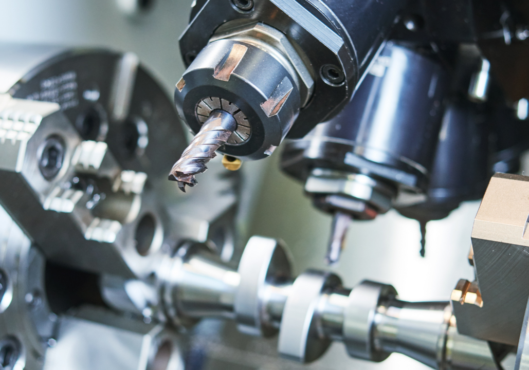 Close-up of CNC machine tool with drill bit and rotating components.