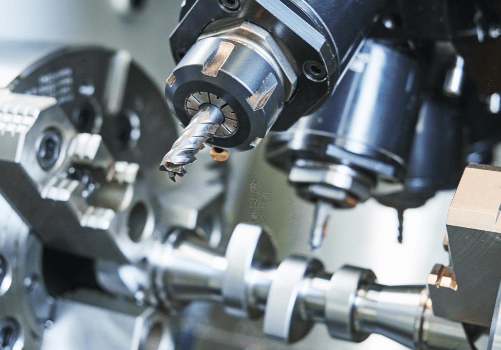 Close-up of CNC machine tool with drill bit and rotating components.